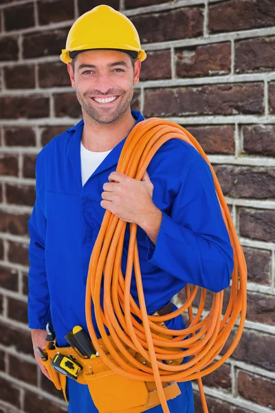 Smiling handyman with rolled wire — Stock Photo, Image