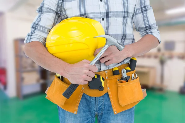 Técnico sosteniendo martillo y sombrero duro — Foto de Stock