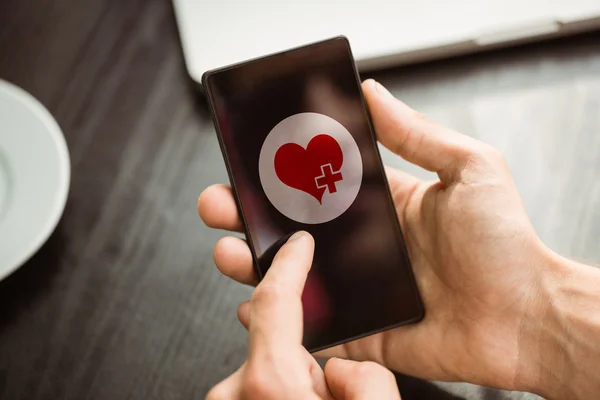 Composite image of hand holding smartphone — Stock Photo, Image