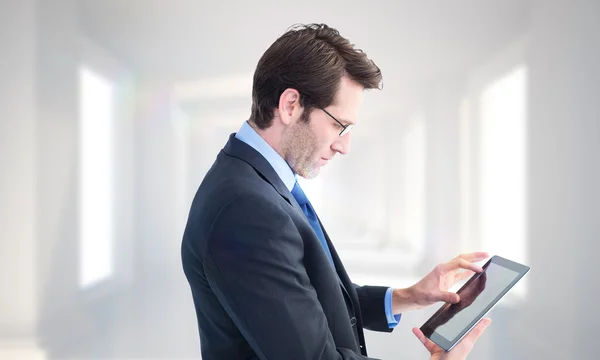 Uomo d'affari in piedi durante l'utilizzo di un tablet — Foto Stock