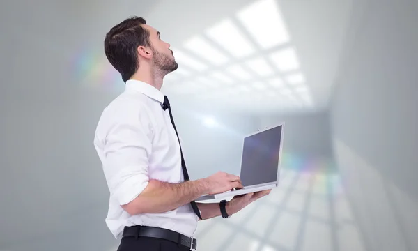 Sofisticato uomo d'affari in piedi e utilizzando un computer portatile — Foto Stock
