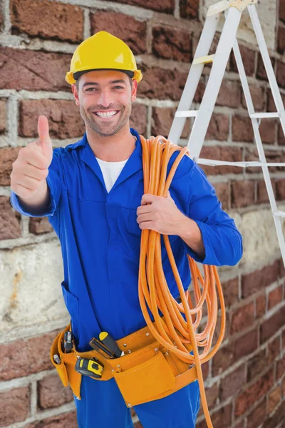 Technician with wire roll gesturing thumbs up — Stock Photo, Image