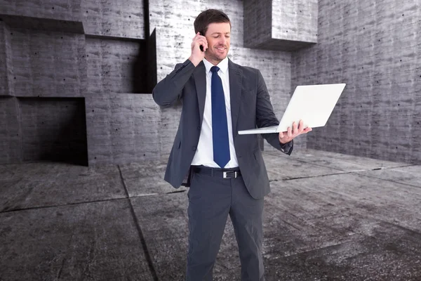 Empresario hablando por teléfono sosteniendo laptop — Foto de Stock