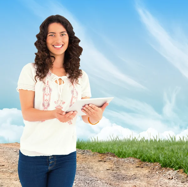 Smiling casual brunette using her tablet pc — Stock Photo, Image