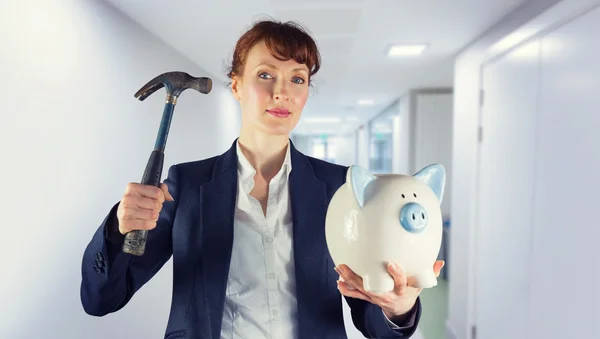 Composite image of businesswoman breaking piggy bank — Stock Photo, Image