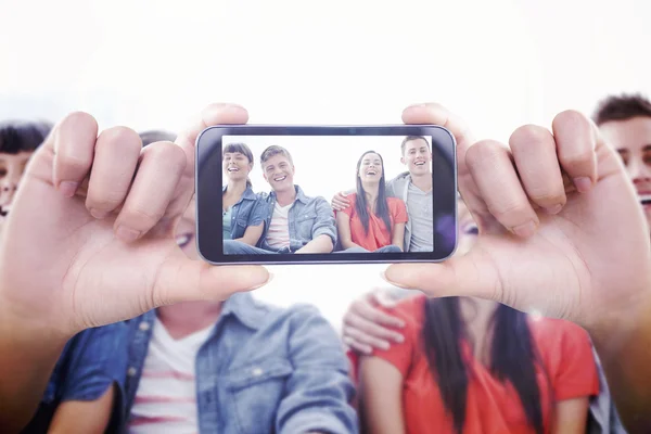 Composite image of hand holding smartphone showing — Stock Photo, Image