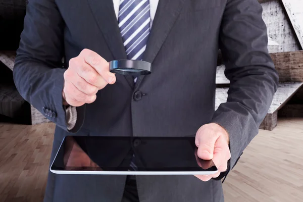 Zakenman kijken naar Tablet PC met Vergrootglas — Stockfoto