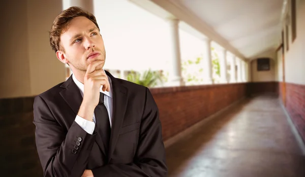 Businessman thinking with hand on chin — Stock Photo, Image