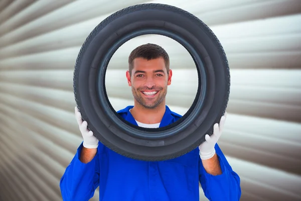 Mechaniker schaut durch Reifen — Stockfoto