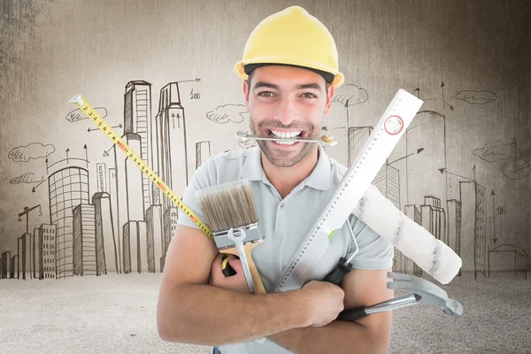 Smiling handyman holding various tools — Stock Photo, Image