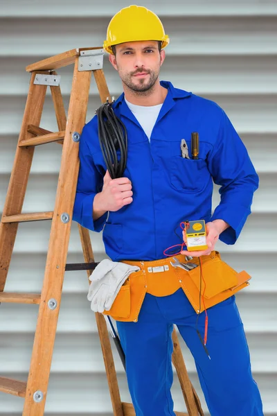 Electrician holding cables and multimeter — Stock Photo, Image