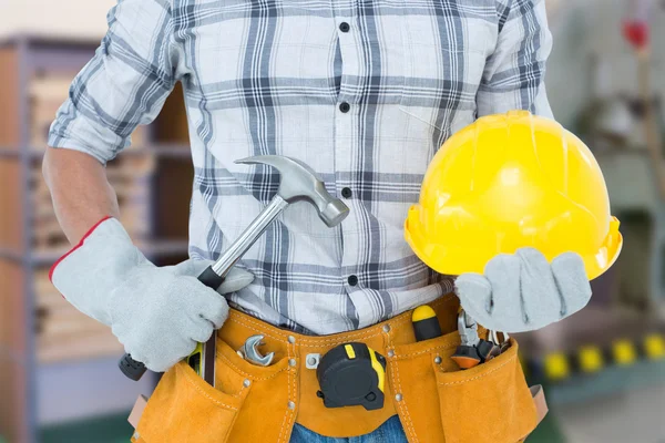 Technician holding hammer and hard hat — Stock Photo, Image
