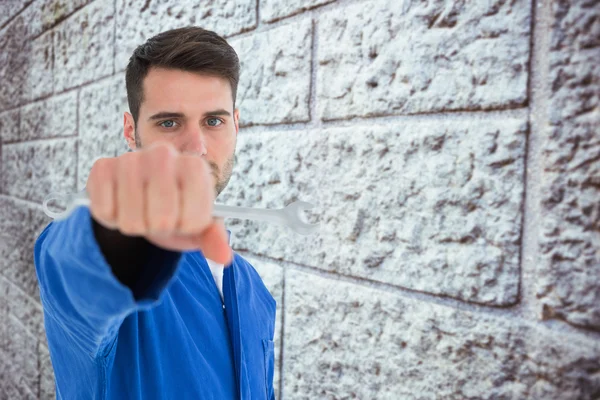 Jovem mecânico masculino segurando chave inglesa — Fotografia de Stock