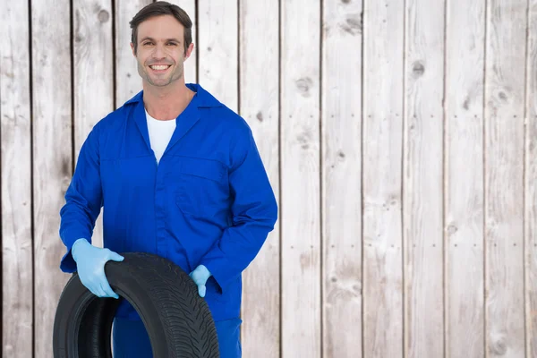 Confident mechanic holding tire — Stock Photo, Image