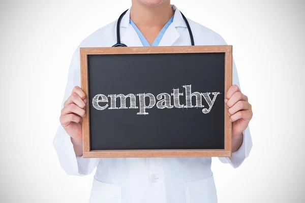 Empathy against doctor showing blackboard — Stock Photo, Image