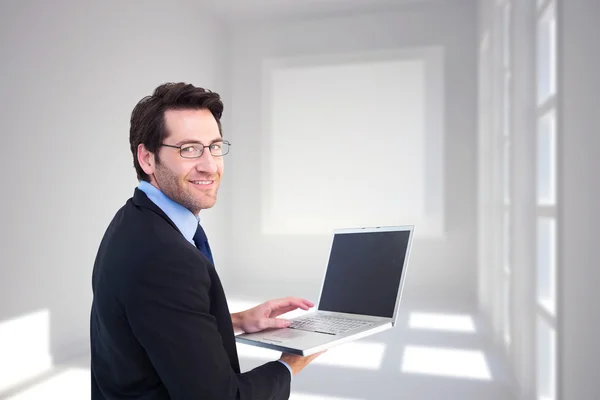Χαμογελώντας επιχειρηματίας χρησιμοποιώντας ένα φορητό υπολογιστή — Φωτογραφία Αρχείου