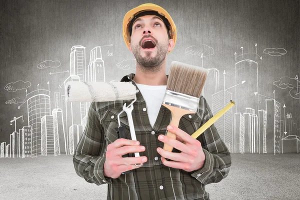 Screaming manual worker holding various tools — Stock Photo, Image