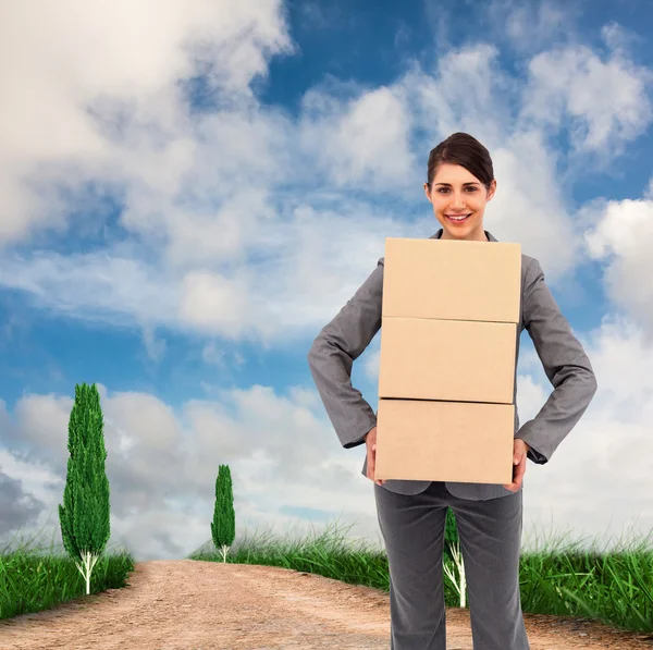 Smiling businesswoman carrying cardboard boxes — Stock Photo, Image