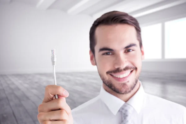Empresário feliz segurando cabo branco — Fotografia de Stock