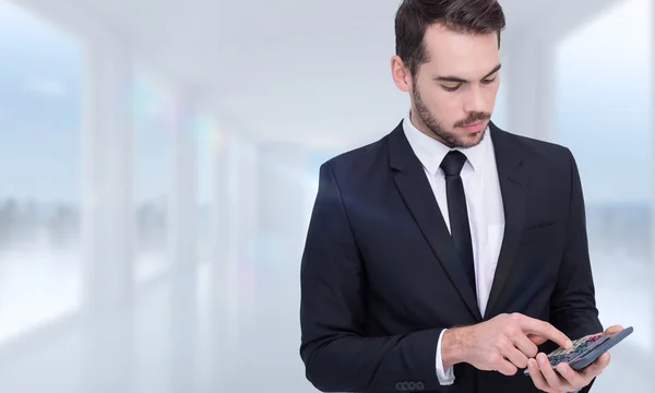 Homem de negócios concentrado em terno usando calculadora — Fotografia de Stock