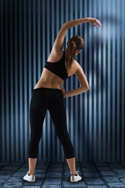 Brunette stretching rear view — Stock Photo, Image