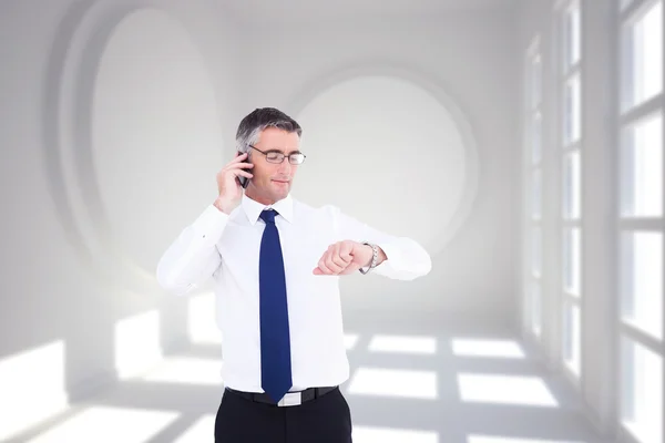 Empresário no telefone olhando para relógio de pulso — Fotografia de Stock