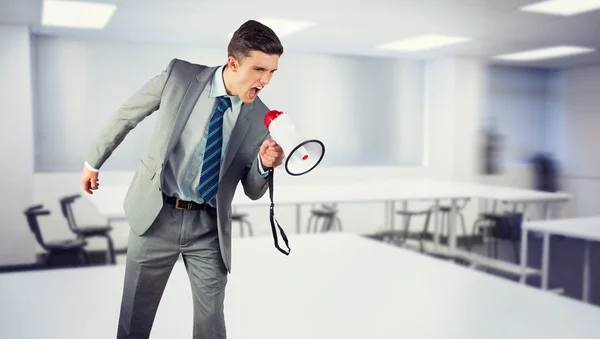 Imagen compuesta del hombre de negocios gritando a través de megáfono — Foto de Stock