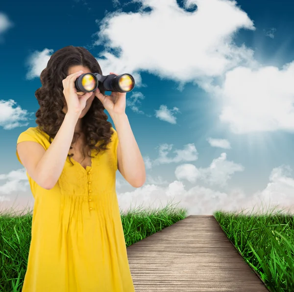 Casual young woman using binoculars — Stock Photo, Image