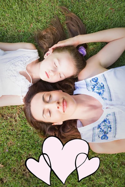 母亲和女儿躺在草地上 — 图库照片