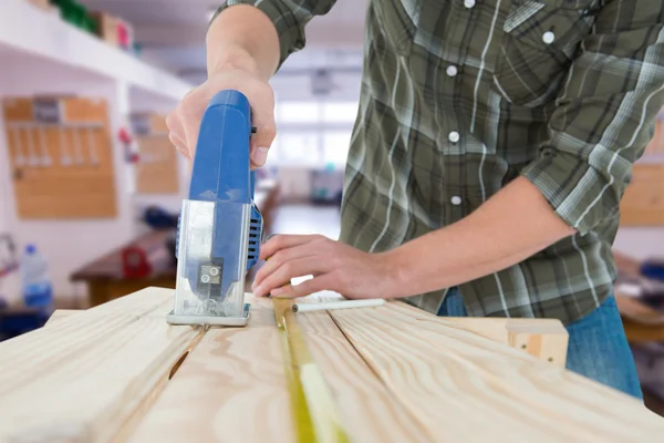 Carpenter cutting wooden plank — Stock Photo, Image