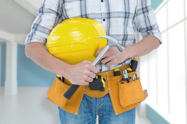 Técnico sosteniendo martillo y sombrero duro — Foto de Stock