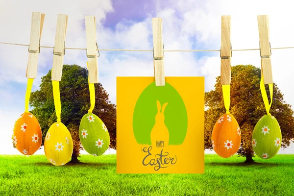 Easter graphic against trees in green field Stock Image