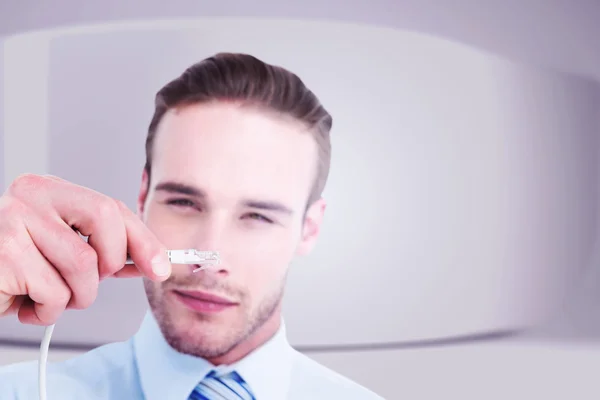 Businessman holding a cable — Stock Photo, Image