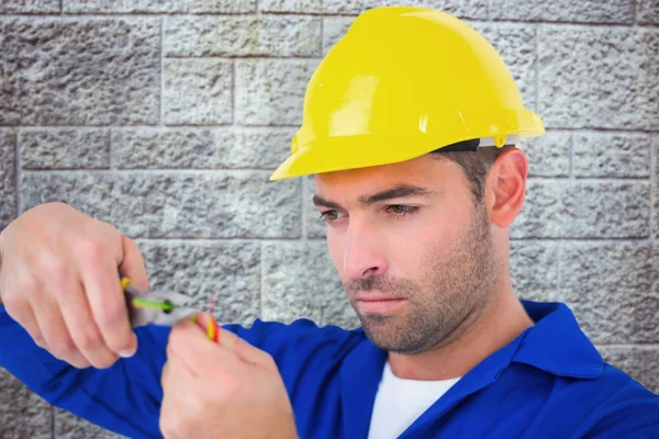 Electrician in hard hat cutting wire — Stock Photo, Image
