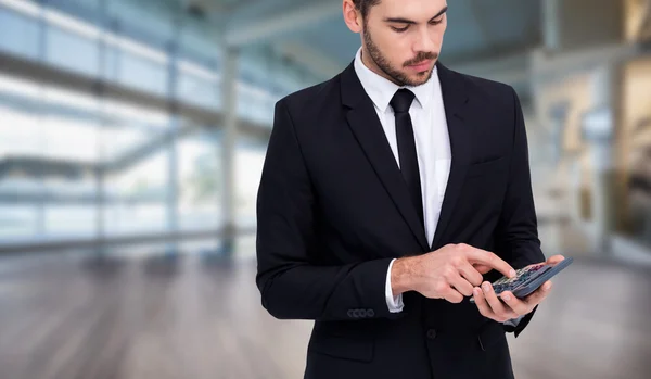 Geconcentreerde zakenman in pak met behulp van calculator — Stockfoto