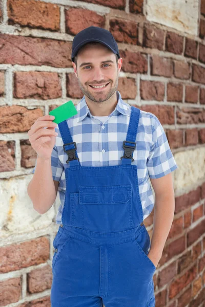 Jovem reparador segurando green card — Fotografia de Stock