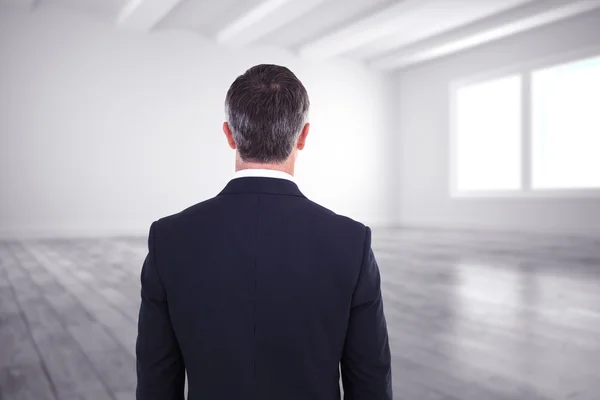 Elegante hombre de negocios contra habitación — Foto de Stock