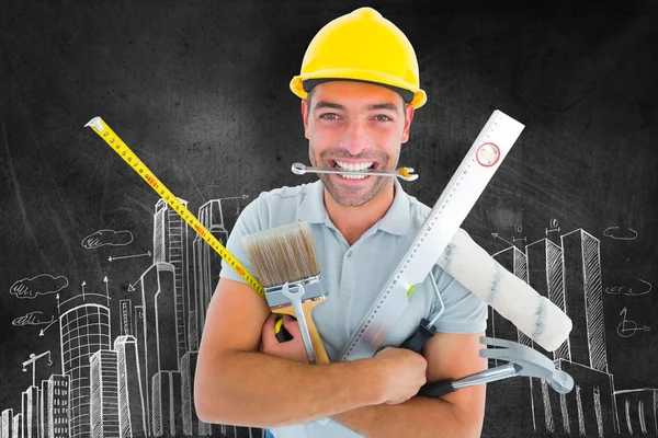 Smiling handyman holding various tools — Stock Photo, Image