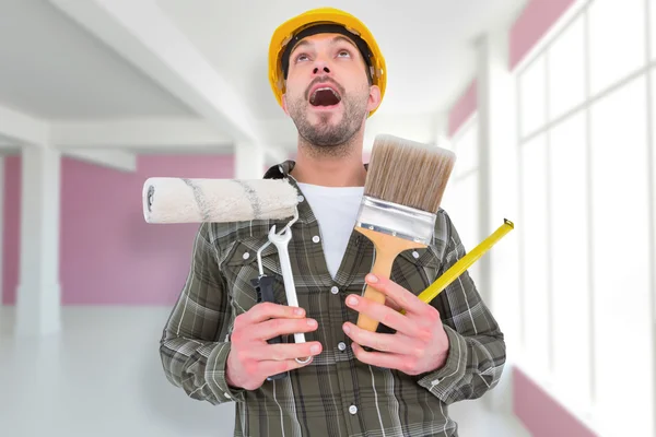 Trabajador manual sosteniendo varias herramientas — Foto de Stock