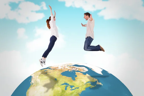 Composite image of couple jumping in the air — Stock Photo, Image