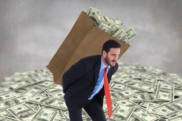 Businessman carrying bag of dollars — Stock Photo, Image