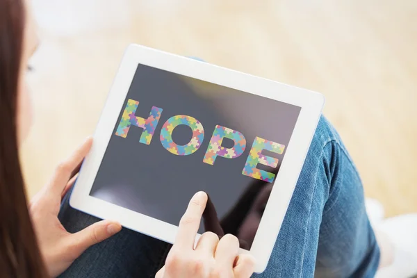 Composite image of teen using a tablet pc sitting on the floor — Stock Photo, Image