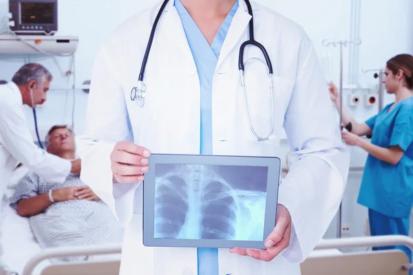 Arzt schaut sich Röntgenbild auf Tablet an — Stockfoto
