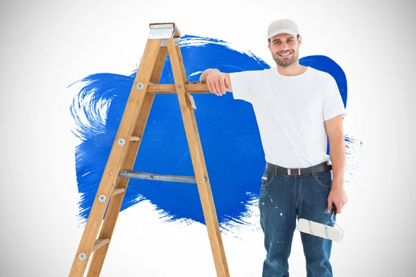 Man with paint roller standing by ladder — Stock Photo, Image