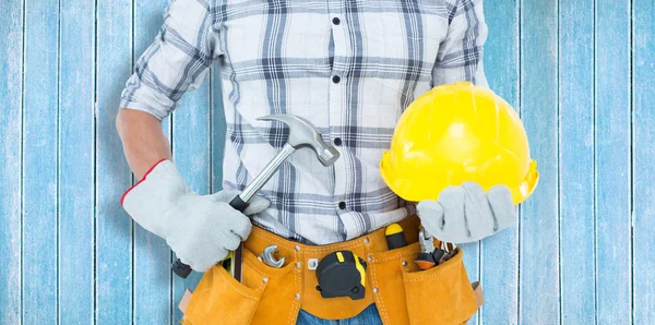 Handyman holding hammer and hard hat — Stock Photo, Image