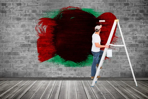 Handyman climbing ladder while using paint — Stock Photo, Image