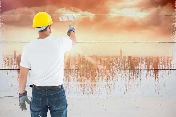 Man bär hardhat samtidigt med hjälp av paint roller — Stockfoto