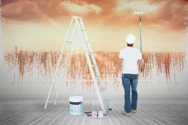 Homem com rolo de pintura em pé por escada — Fotografia de Stock