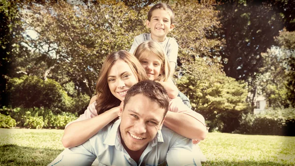 Glückliche Familienmitglieder, die aufeinander liegen — Stockfoto