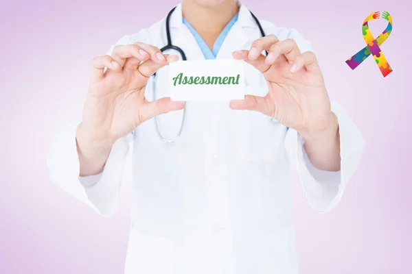 Word assessment and doctor holding card — Stock Photo, Image